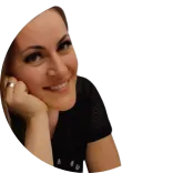 Dr Diana Nuca, a dental professional in the UK, smiling woman with long hair resting her chin on her hand, wearing a black top, against a transparent background.